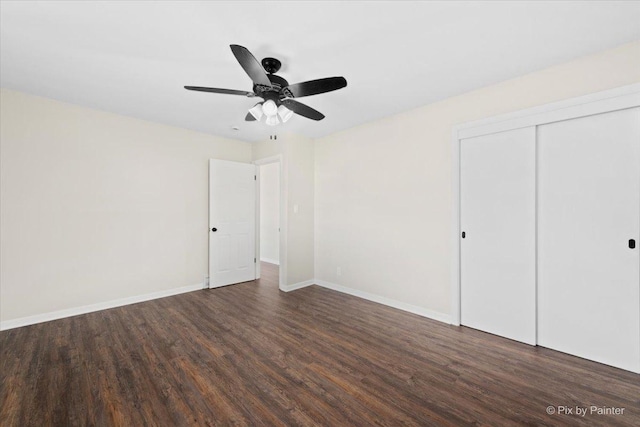 unfurnished bedroom featuring ceiling fan, a closet, and dark wood-type flooring