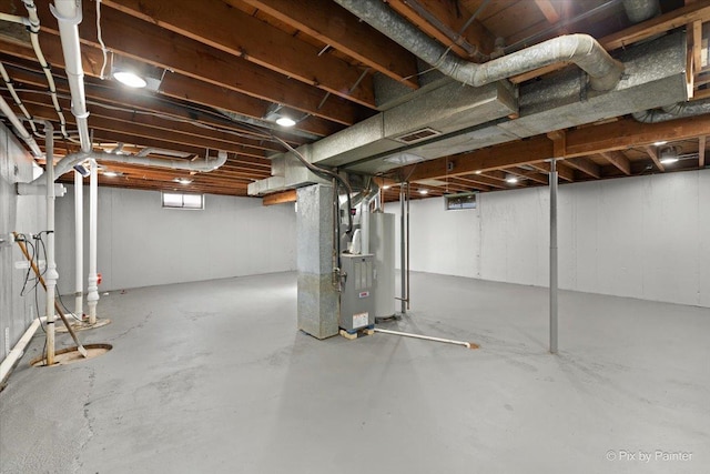 basement featuring gas water heater and heating unit