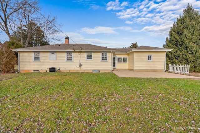 rear view of property with a lawn, cooling unit, and a patio