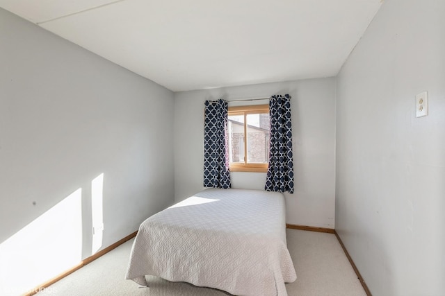 bedroom featuring baseboards and light colored carpet