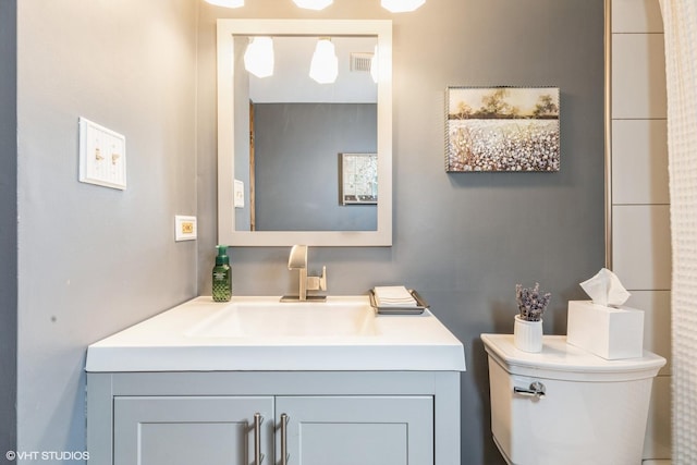 bathroom featuring visible vents, vanity, and toilet