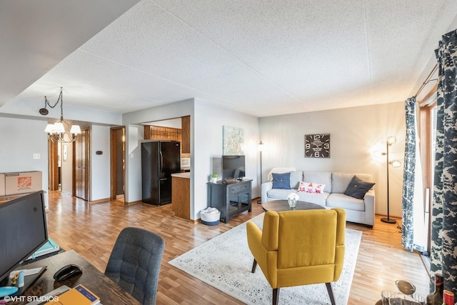 living room featuring a textured ceiling, light hardwood / wood-style flooring, and a chandelier