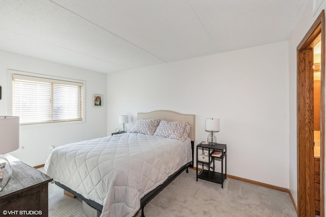 bedroom featuring baseboards and light colored carpet