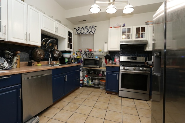 kitchen featuring blue cabinetry, pendant lighting, white cabinetry, and stainless steel appliances