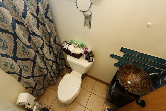 bathroom with a shower with curtain, tile patterned flooring, and toilet