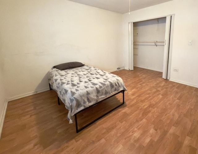 bedroom with wood-type flooring and a closet