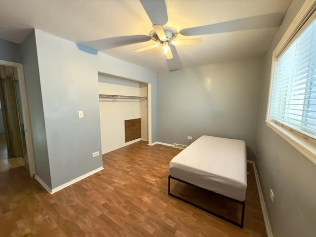 sitting room with hardwood / wood-style floors and ceiling fan