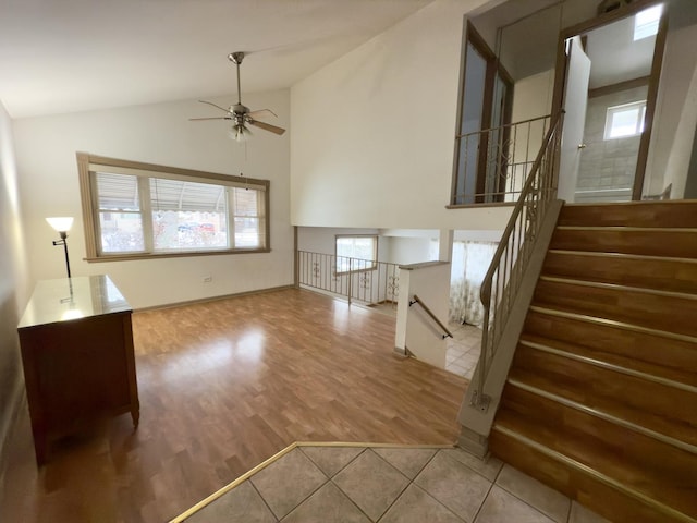 unfurnished living room featuring plenty of natural light, ceiling fan, light hardwood / wood-style flooring, and lofted ceiling