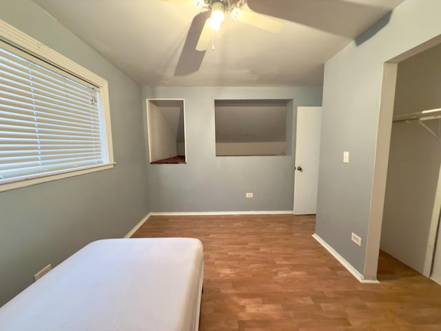 unfurnished bedroom featuring ceiling fan, a closet, and wood-type flooring