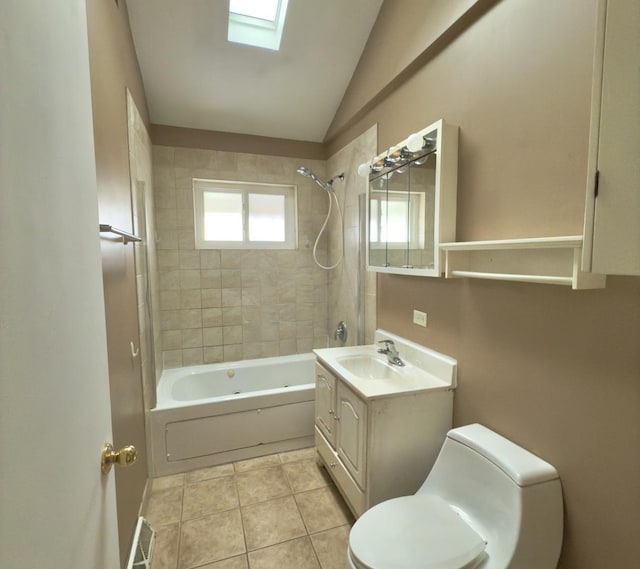 full bathroom with tiled shower / bath combo, tile patterned flooring, toilet, vaulted ceiling with skylight, and vanity