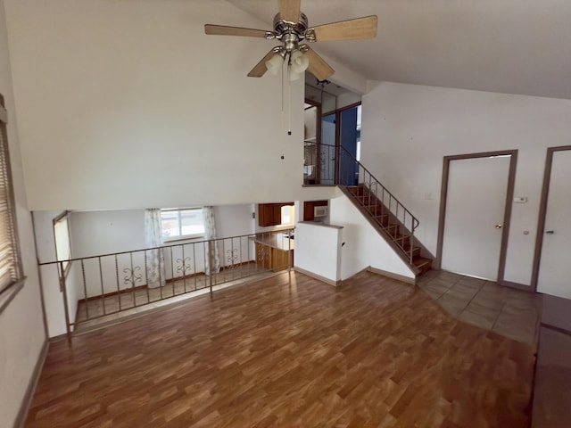 unfurnished living room featuring ceiling fan, dark hardwood / wood-style floors, and vaulted ceiling