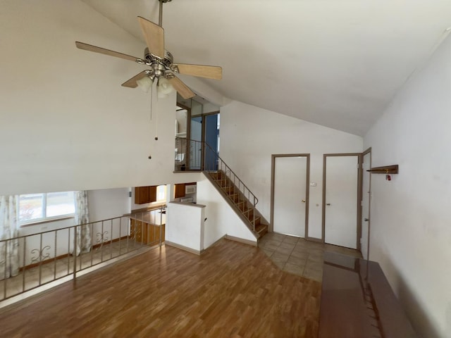 unfurnished living room with hardwood / wood-style flooring, ceiling fan, and vaulted ceiling