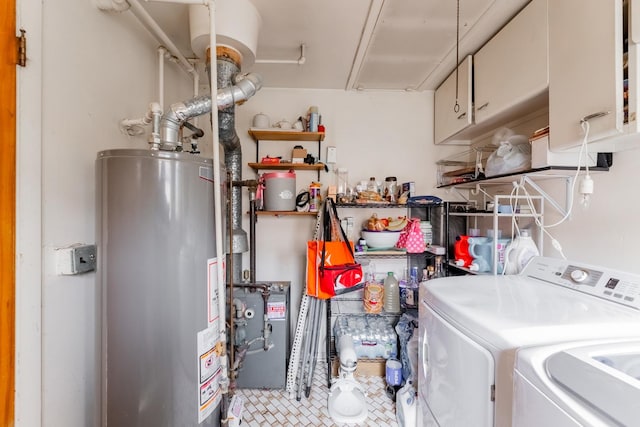 laundry room featuring cabinets, gas water heater, and washing machine and clothes dryer