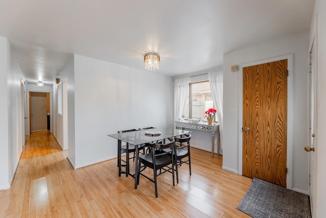 dining area featuring an inviting chandelier and light hardwood / wood-style flooring