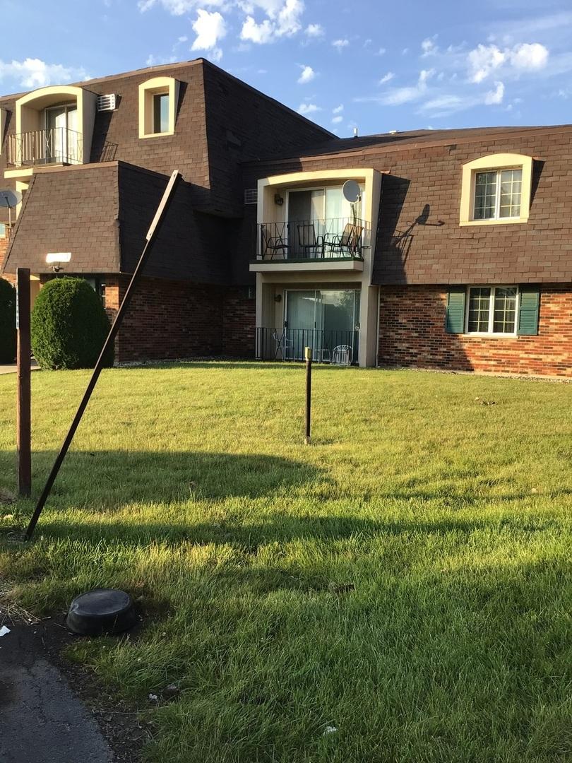 view of front of home with a balcony and a front lawn