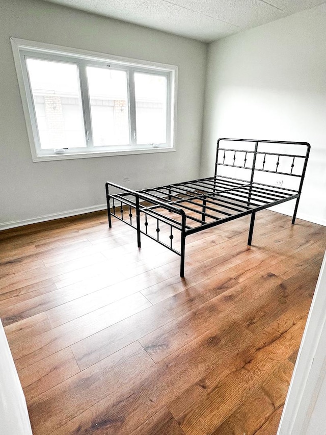 bedroom with a textured ceiling and light hardwood / wood-style flooring