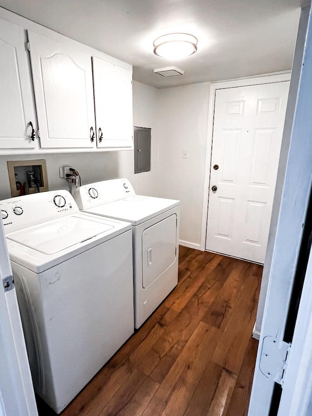 clothes washing area featuring washing machine and clothes dryer, electric panel, dark wood-type flooring, and cabinets