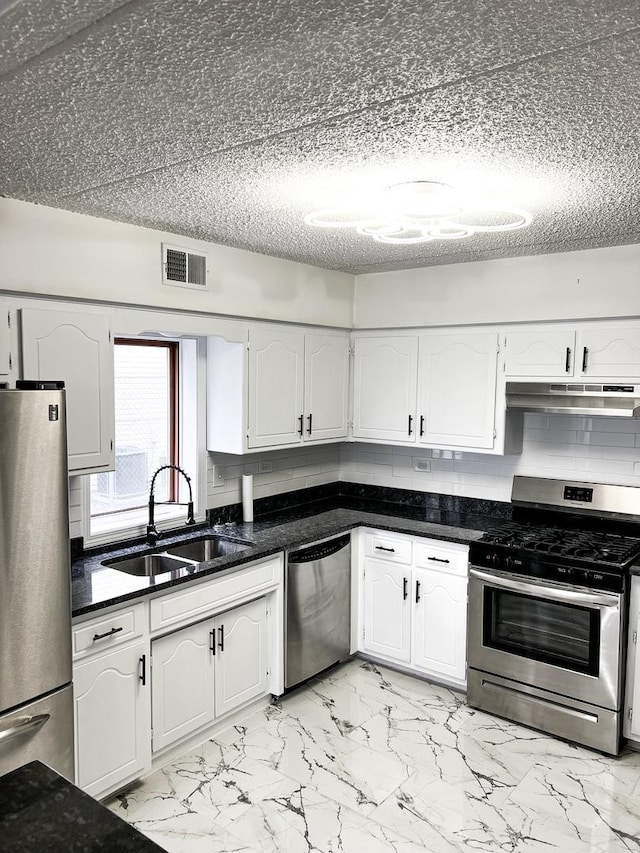 kitchen with white cabinets, sink, a textured ceiling, tasteful backsplash, and stainless steel appliances