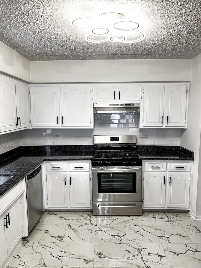 kitchen with white cabinets, appliances with stainless steel finishes, a textured ceiling, and decorative backsplash