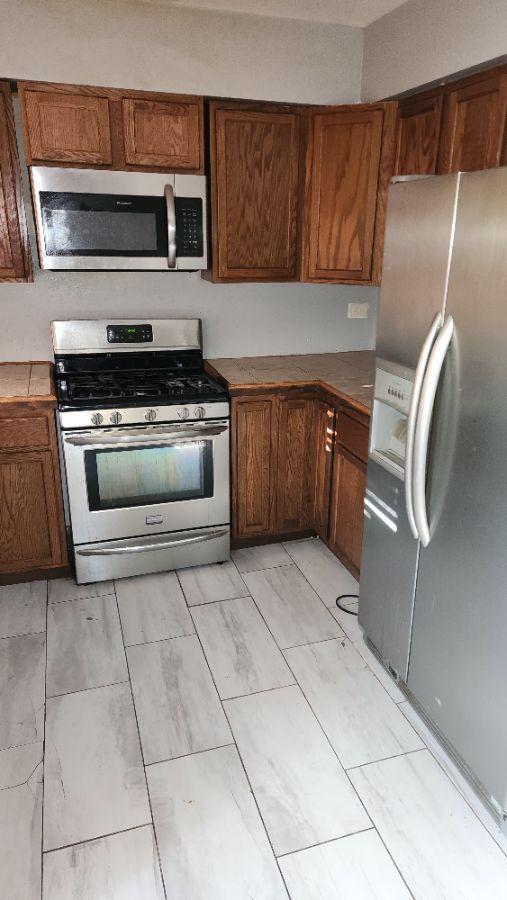 kitchen featuring tile counters and appliances with stainless steel finishes