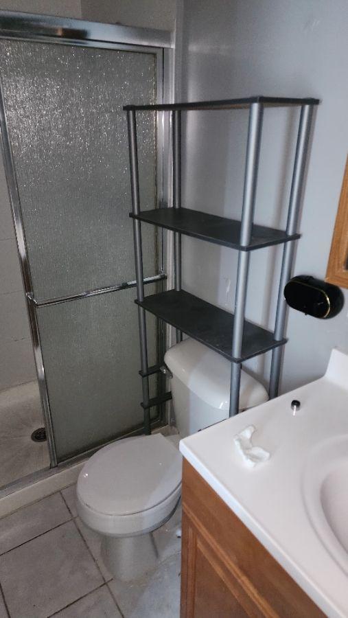 bathroom featuring tile patterned floors, vanity, an enclosed shower, and toilet