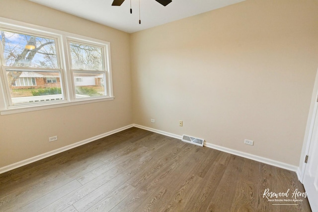 spare room featuring ceiling fan and dark wood-type flooring