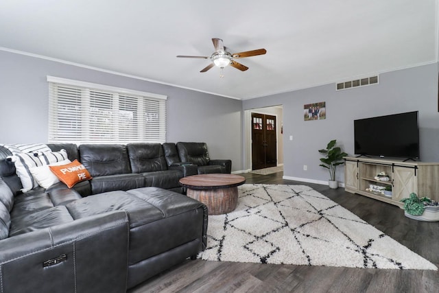 living room featuring ceiling fan, ornamental molding, and dark wood-type flooring