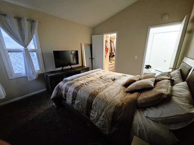 bedroom featuring carpet flooring, a walk in closet, a closet, and vaulted ceiling