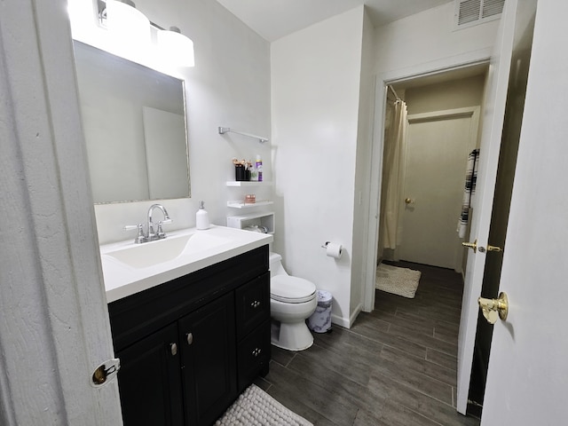 bathroom with vanity, toilet, and wood-type flooring