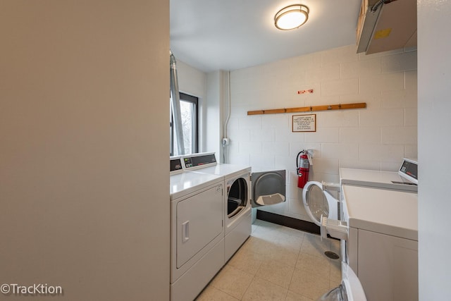 laundry area with washing machine and dryer and tile walls