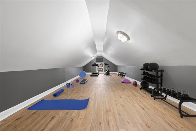 workout room with wood-type flooring and vaulted ceiling