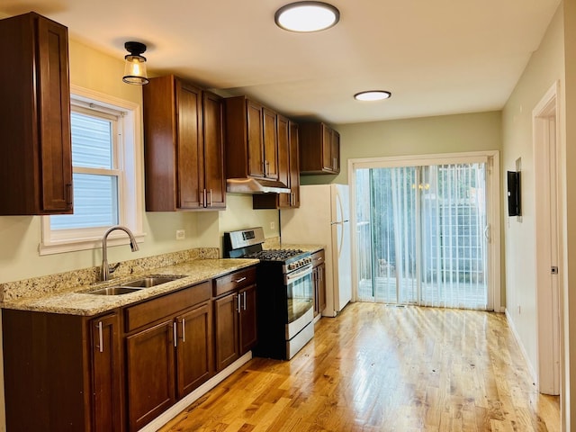 kitchen with stainless steel gas stove, light hardwood / wood-style flooring, plenty of natural light, and sink