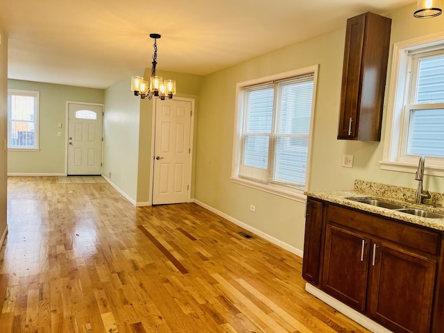 unfurnished dining area featuring plenty of natural light, light wood-type flooring, and sink