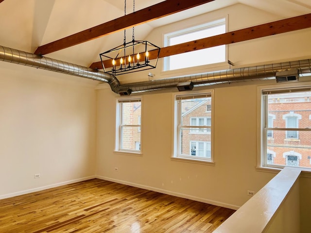 spare room featuring a notable chandelier, light hardwood / wood-style floors, and high vaulted ceiling