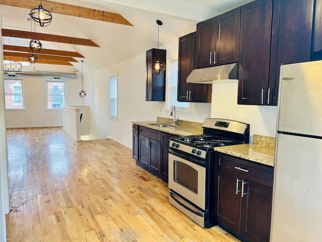 kitchen featuring sink, stainless steel gas range oven, white fridge, pendant lighting, and light hardwood / wood-style floors