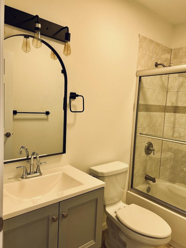 full bathroom with shower / bath combination with glass door, vanity, and toilet