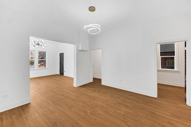 unfurnished living room featuring a chandelier and hardwood / wood-style floors