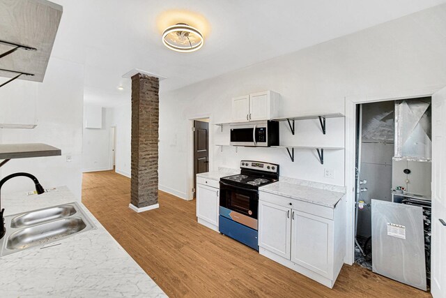 kitchen featuring ornate columns, sink, light hardwood / wood-style flooring, white cabinets, and appliances with stainless steel finishes