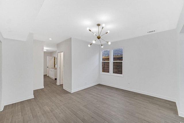 spare room featuring light hardwood / wood-style floors, an inviting chandelier, and sink