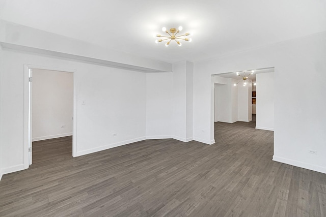 unfurnished room with dark hardwood / wood-style flooring and a notable chandelier