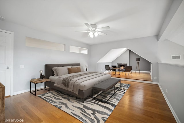 bedroom featuring ceiling fan, wood-type flooring, and beam ceiling