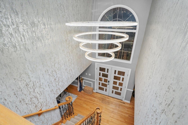 interior space with hardwood / wood-style floors, french doors, and a notable chandelier