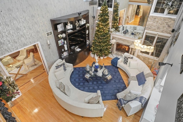 living room featuring a fireplace, hardwood / wood-style floors, and a high ceiling