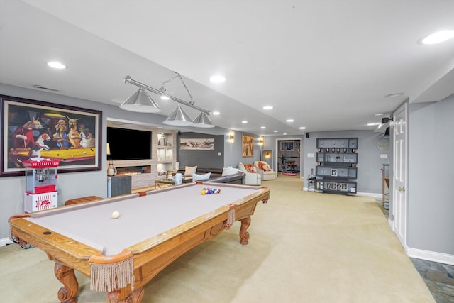 recreation room featuring a stone fireplace, light colored carpet, and billiards