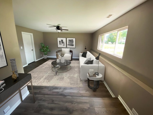 living room featuring ceiling fan and dark hardwood / wood-style floors