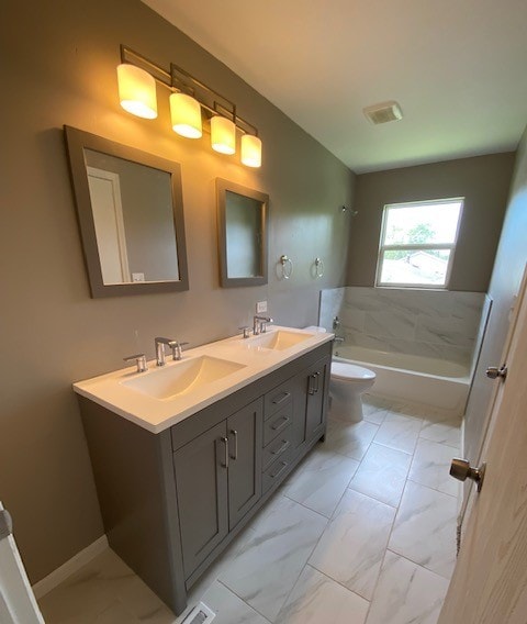 full bathroom featuring vanity, bathing tub / shower combination, and toilet