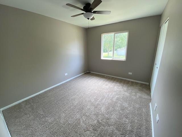 spare room with carpet and ceiling fan