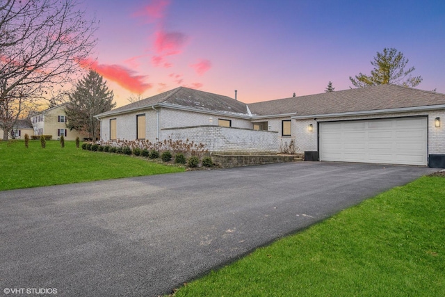 ranch-style house with a lawn and a garage