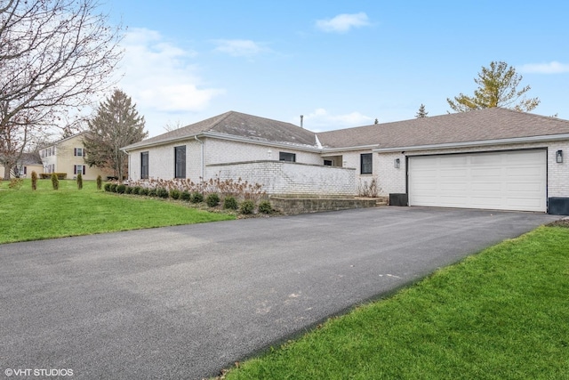 single story home with a garage and a front lawn