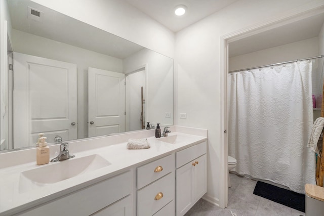 bathroom featuring tile patterned flooring, vanity, and toilet